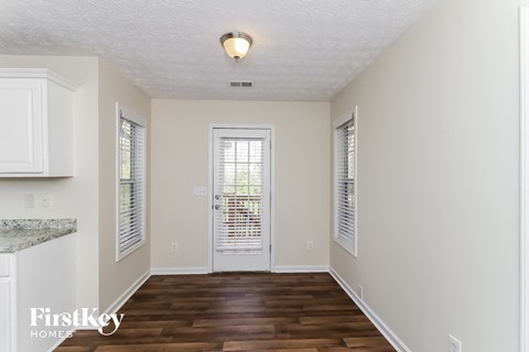 A room with a wooden floor and a white door.
