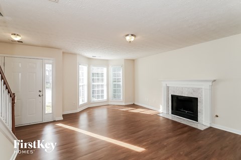A living room with a fireplace and wooden floors.