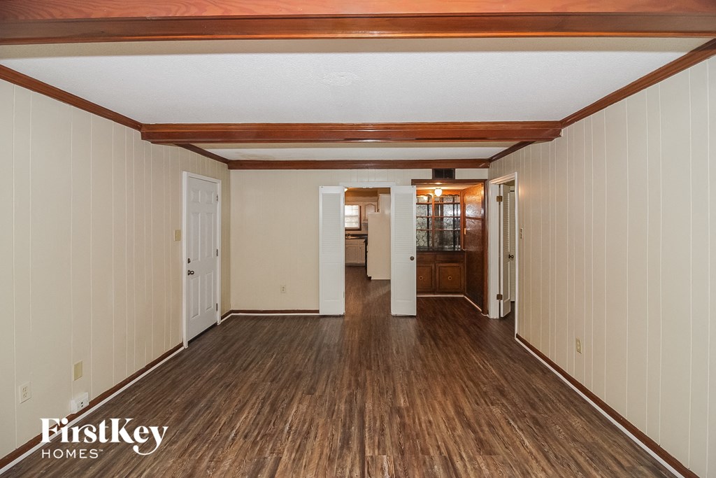 A spacious room with wooden floors and white walls.