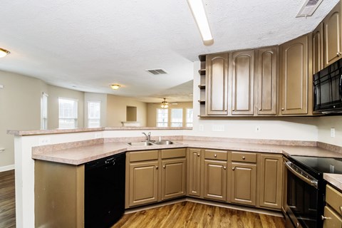 A kitchen with wooden cabinets and black appliances.