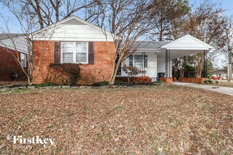 a small brick house with a yard in front of it