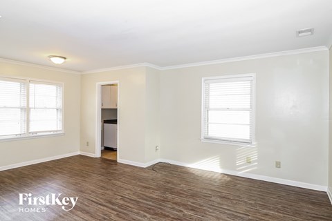 a living room with a hard wood floor and white walls
