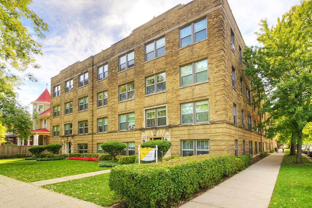 a large brick building with a sidewalk in front of it