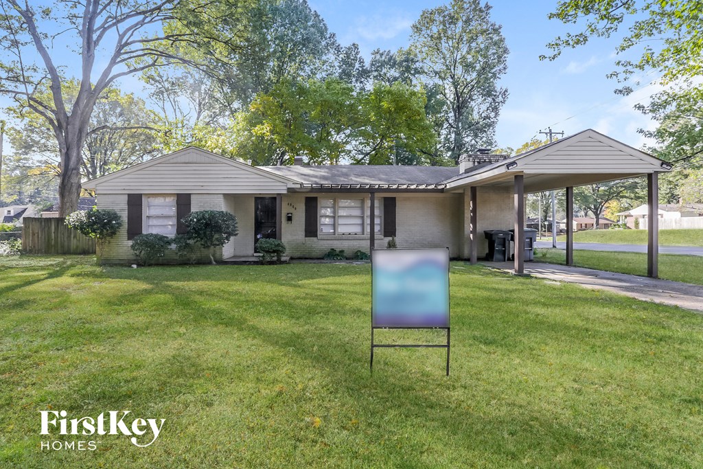 a house with a sign in the lawn in front of it