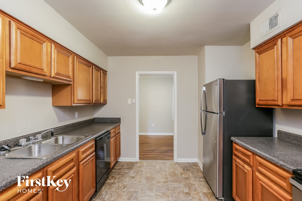 a kitchen with wood cabinets and stainless steel appliances and a black refrigerator
