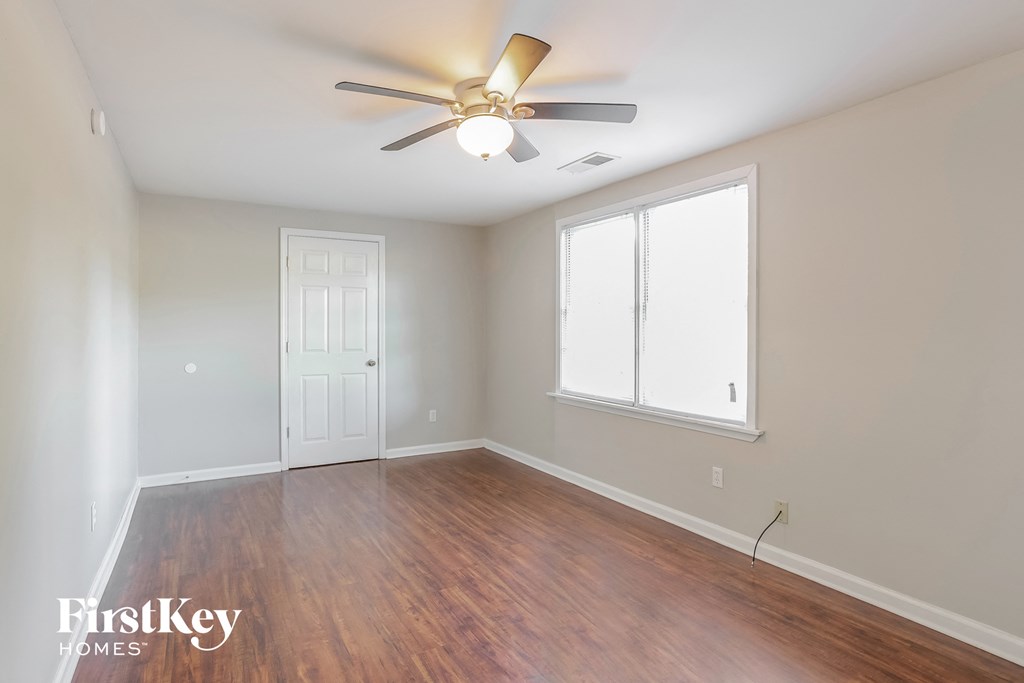 an empty room with a ceiling fan and a window