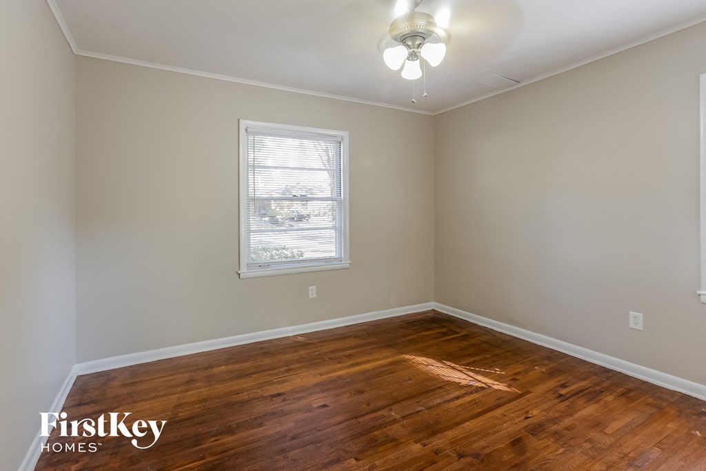 a bedroom with wood flooring and a window