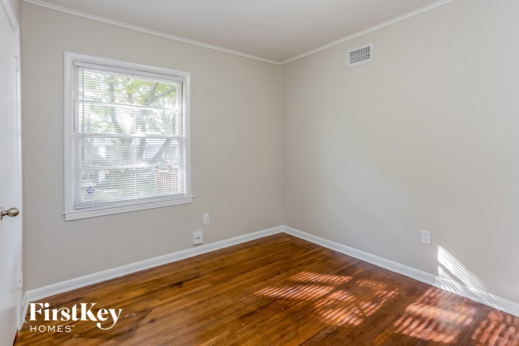 the living room of a home with wood floors and a window
