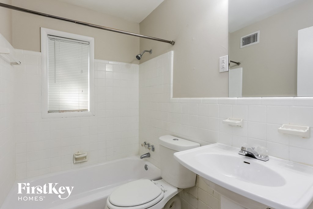 a white bathroom with a sink toilet and bath tub
