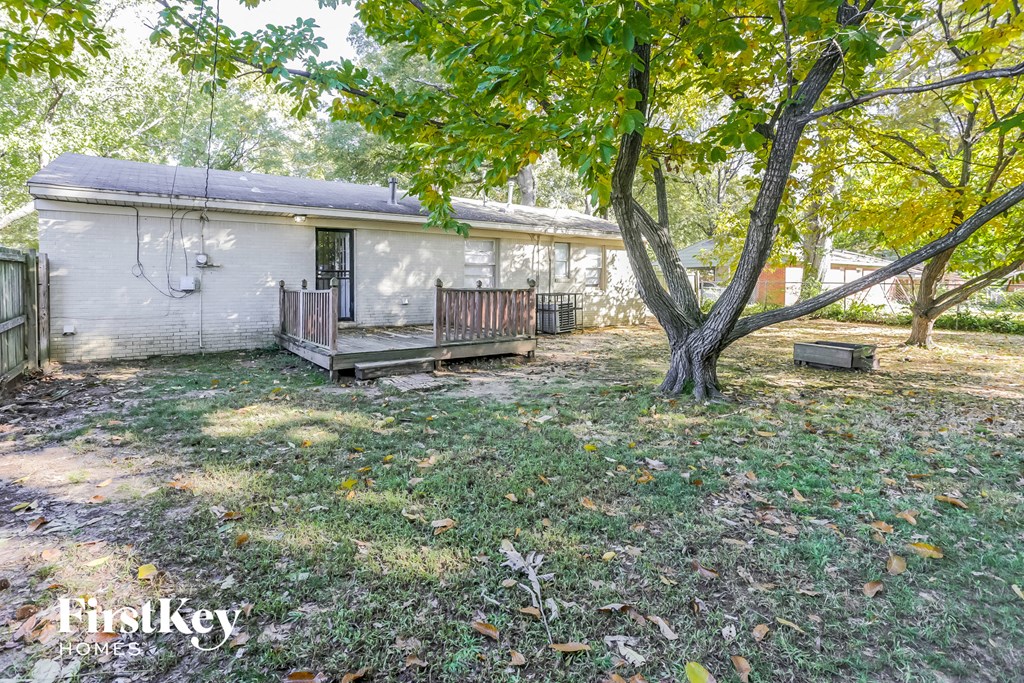 a small white house with a yard and a tree