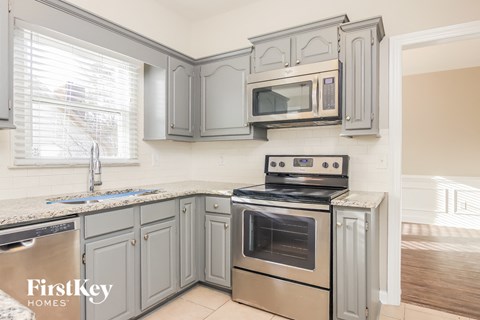 A kitchen with a stove top oven and microwave above it.