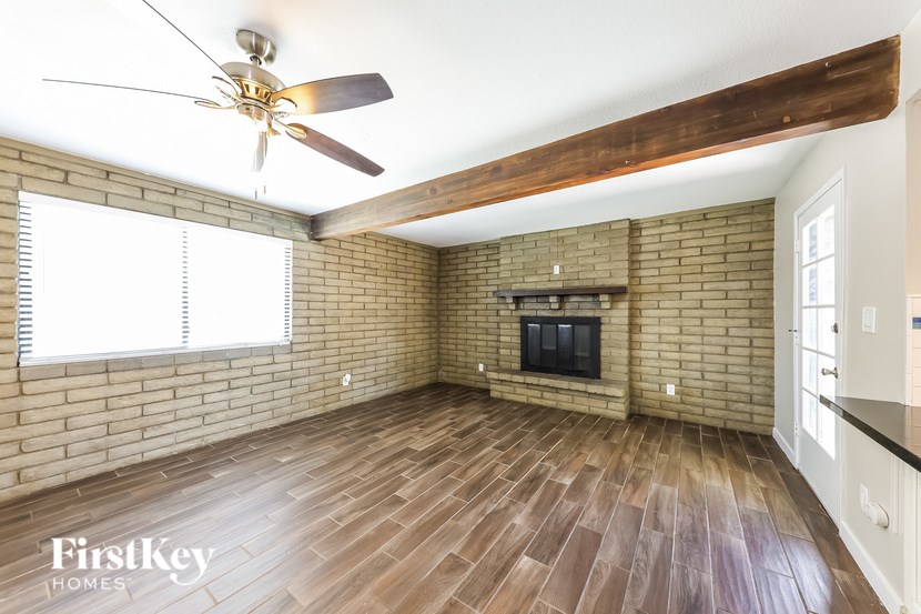 A room with a brick wall and wooden flooring.