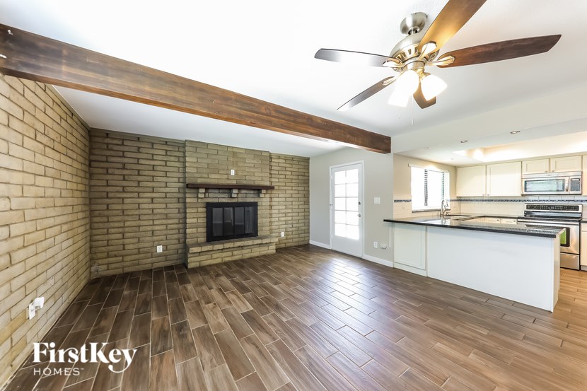 A well-lit living room with a brick wall and a fireplace.
