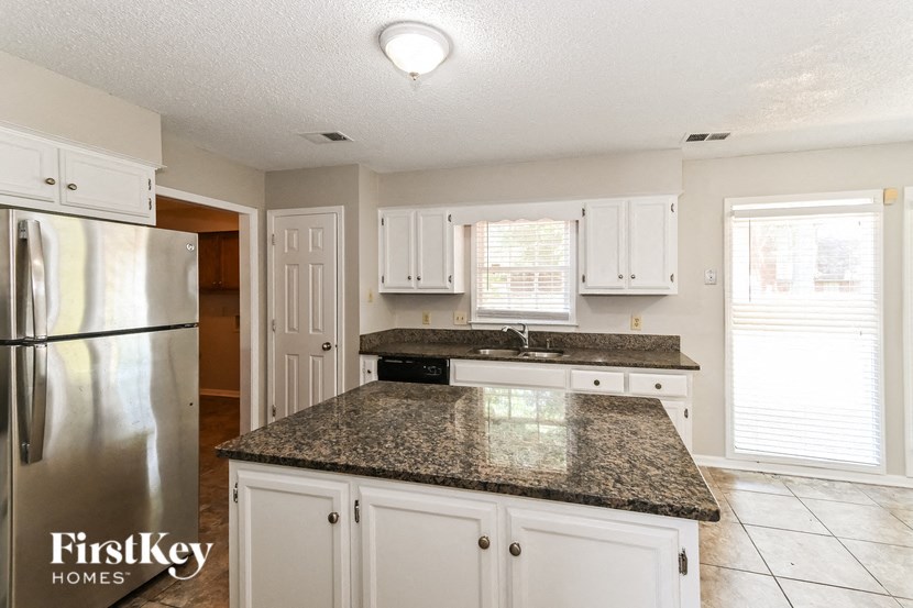 a kitchen with white cabinets and granite counter tops