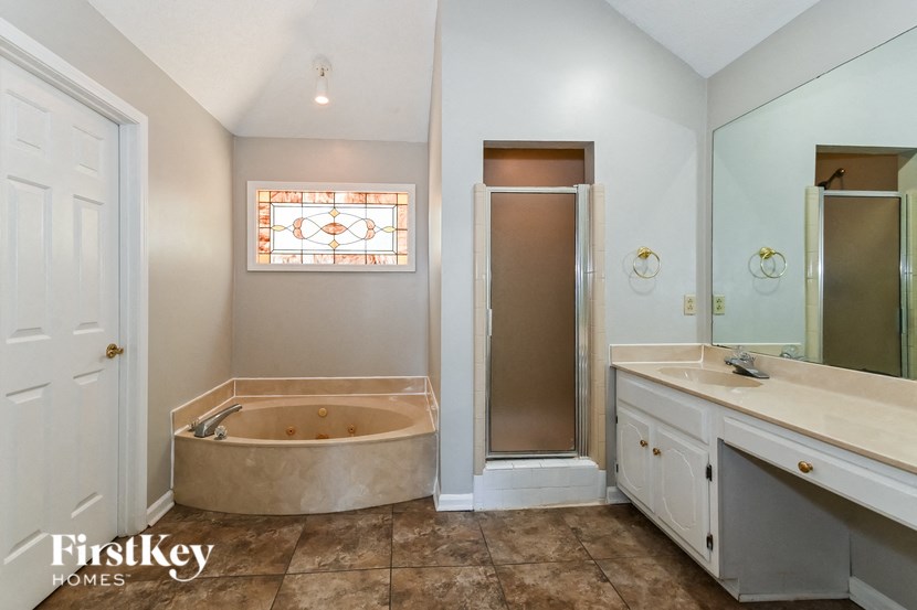 a bathroom with a tub and a sink and a shower