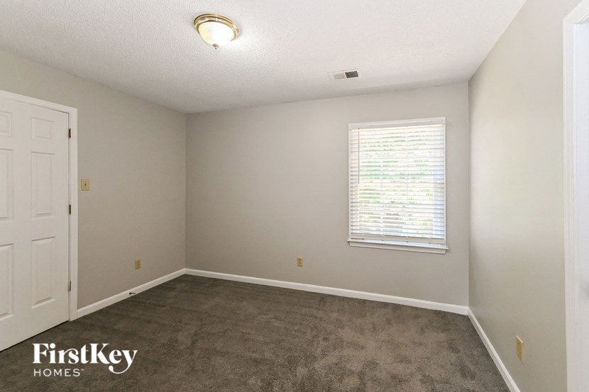 a bedroom with a carpeted floor and a window