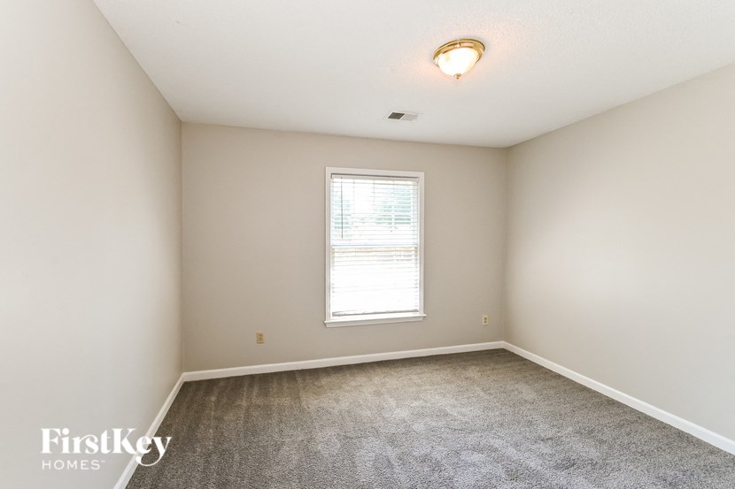an empty room with carpet and a window