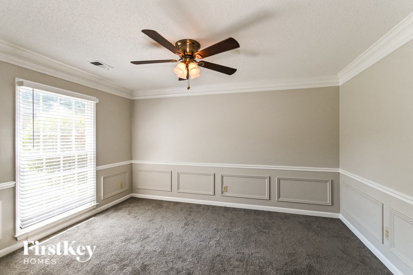 a dining room with a ceiling fan and a window