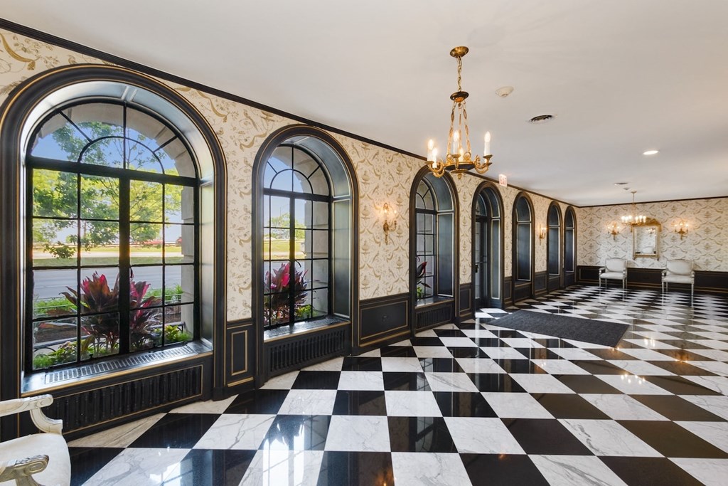 the lobby of a hotel with large windows and a checkered floor