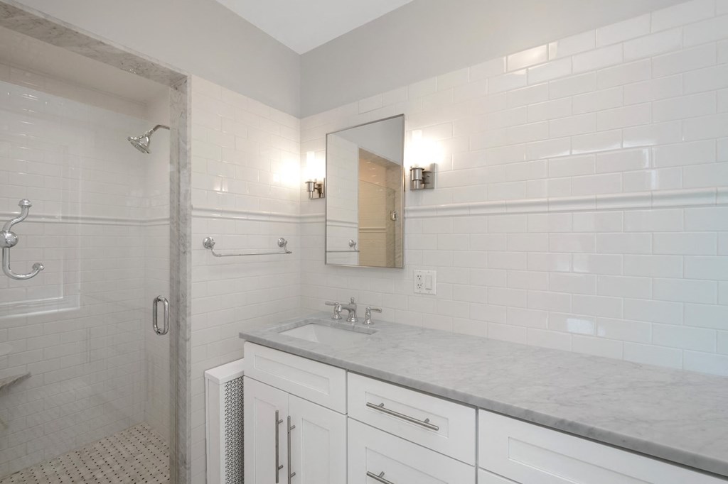 a white bathroom with a sink and a shower