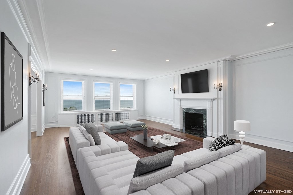 a living room with a large white couch and a fireplace