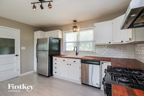 A kitchen with a stove top oven and a refrigerator.