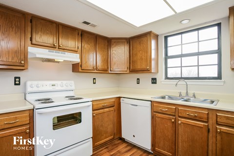 a kitchen with white appliances and wooden cabinets