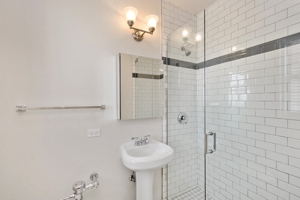 a white bathroom with a sink and a shower