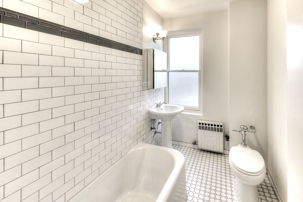 a white bathroom with a tub sink and toilet