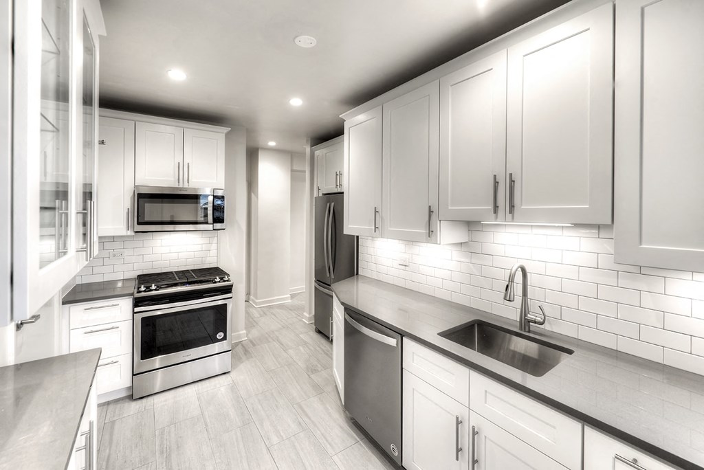 a kitchen with white cabinets and stainless steel appliances