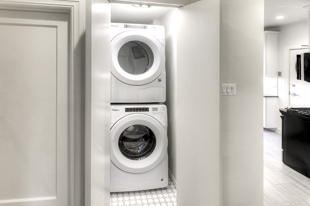 a white washer and dryer in a white laundry room