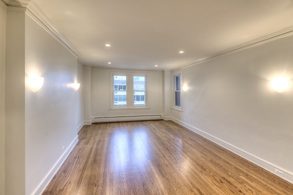 an empty living room with white walls and a window