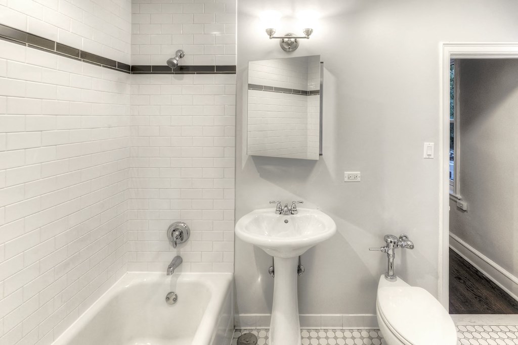 a white bathroom with a sink and a tub and a toilet