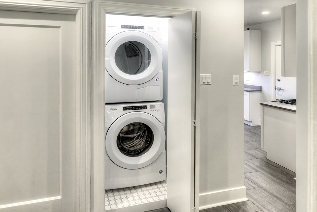a white washer and dryer in a white laundry room