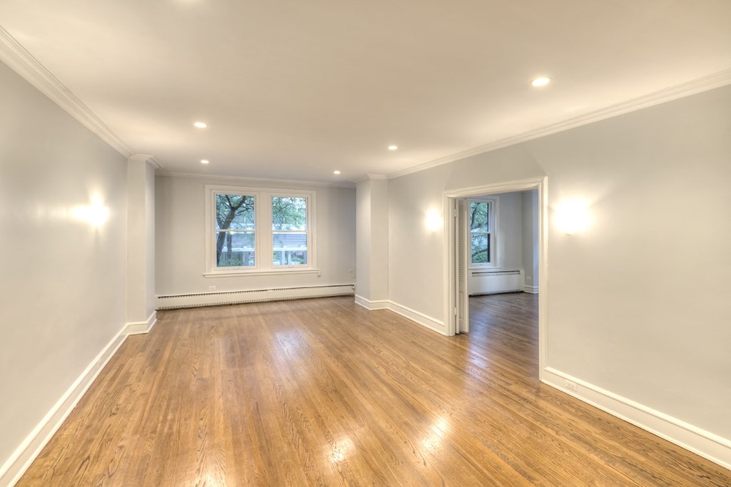 a living room with white walls and wood floors