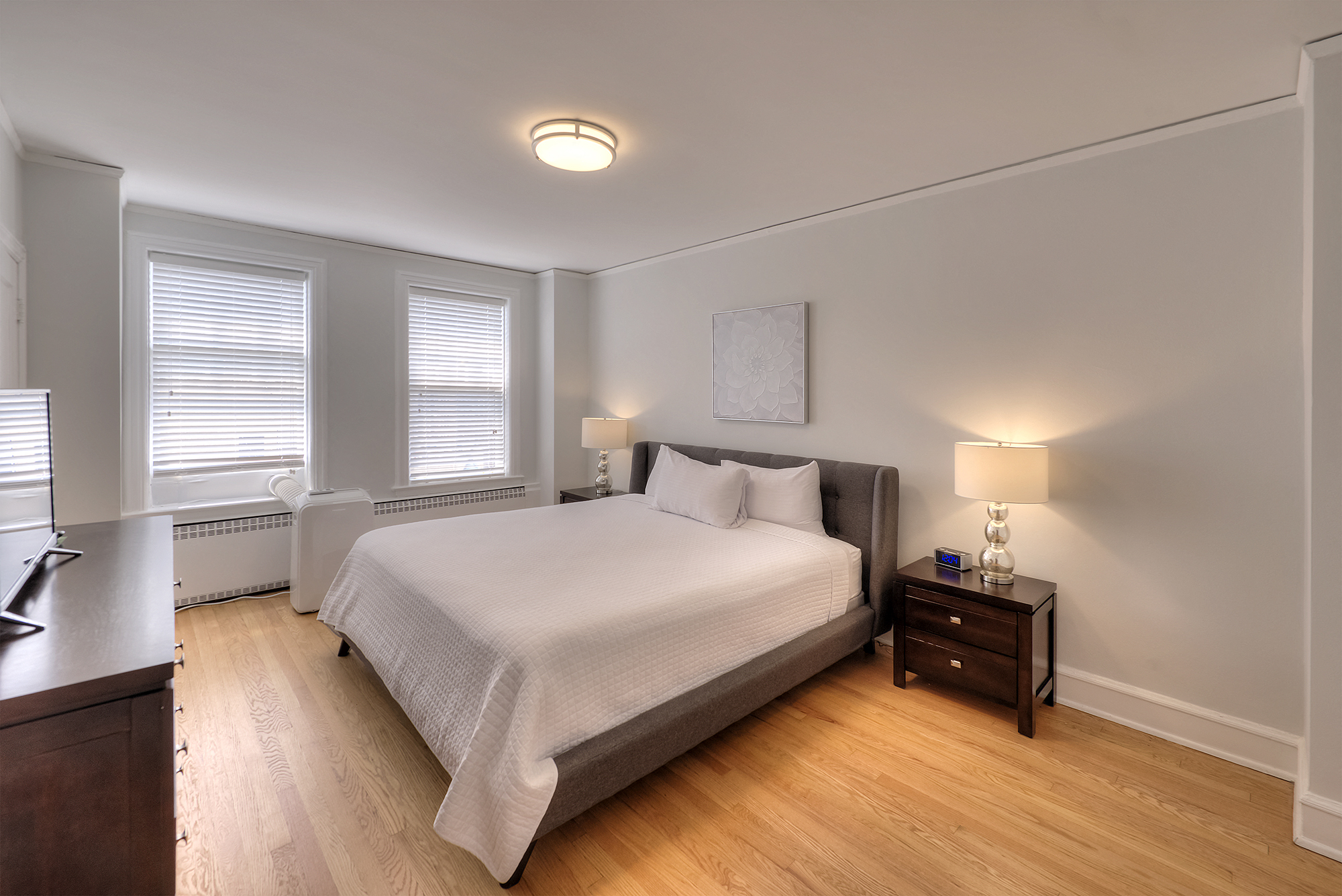 a bedroom with a bed and two windows