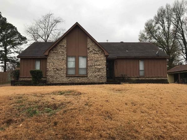 A house with a brown stone facade and a brown roof.