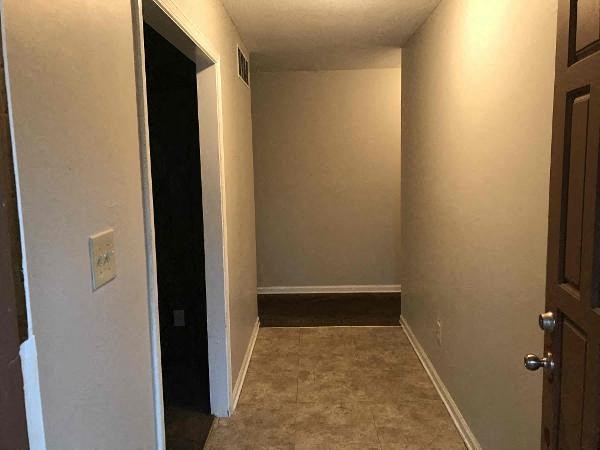A hallway with a door on the left and a door on the right.
