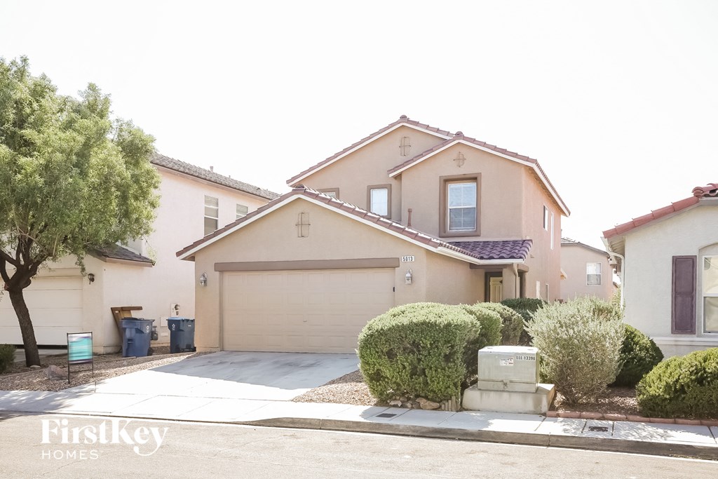 a beige house with a garage and a driveway