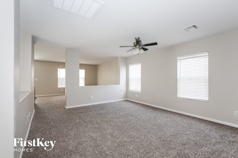 a living room with carpet and a ceiling fan