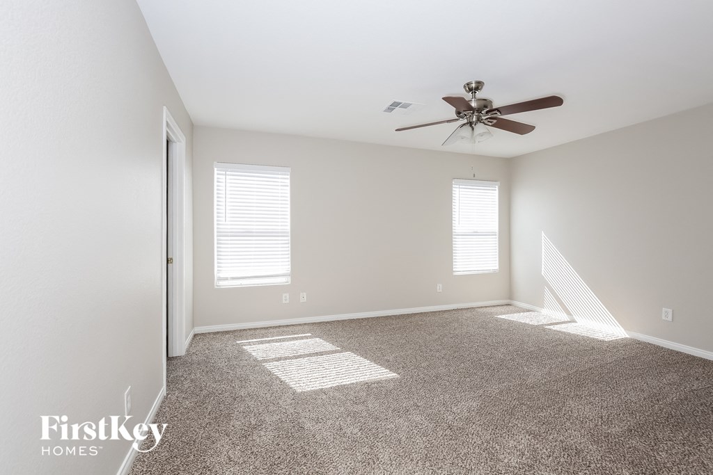 a living room with carpet and a ceiling fan