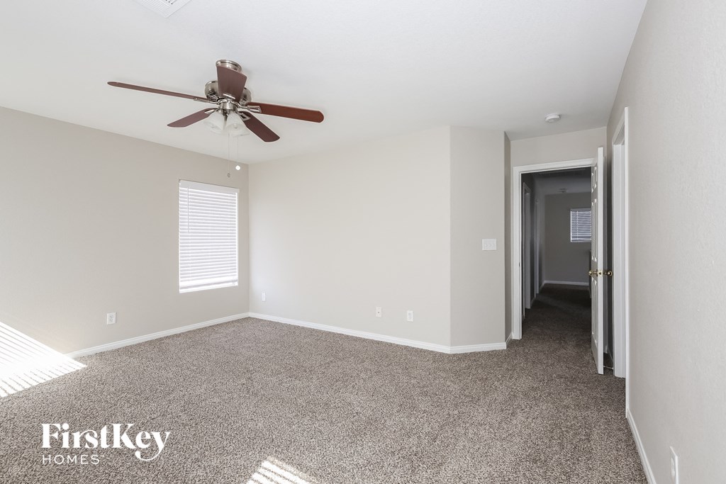 a living room with carpet and a ceiling fan