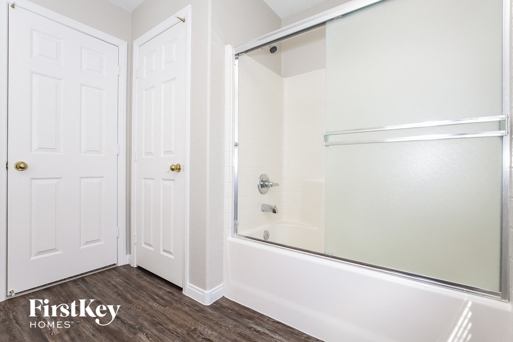 a bathroom with a shower and a white door