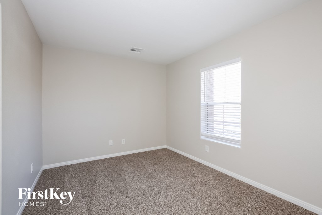 a empty room with carpet and a window