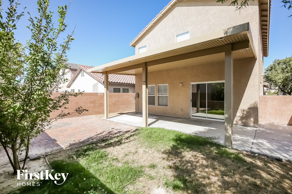 the backyard of a house with a patio and a yard
