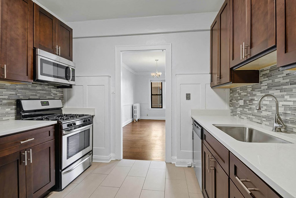 a kitchen with a sink and a stove and a door to a hallway