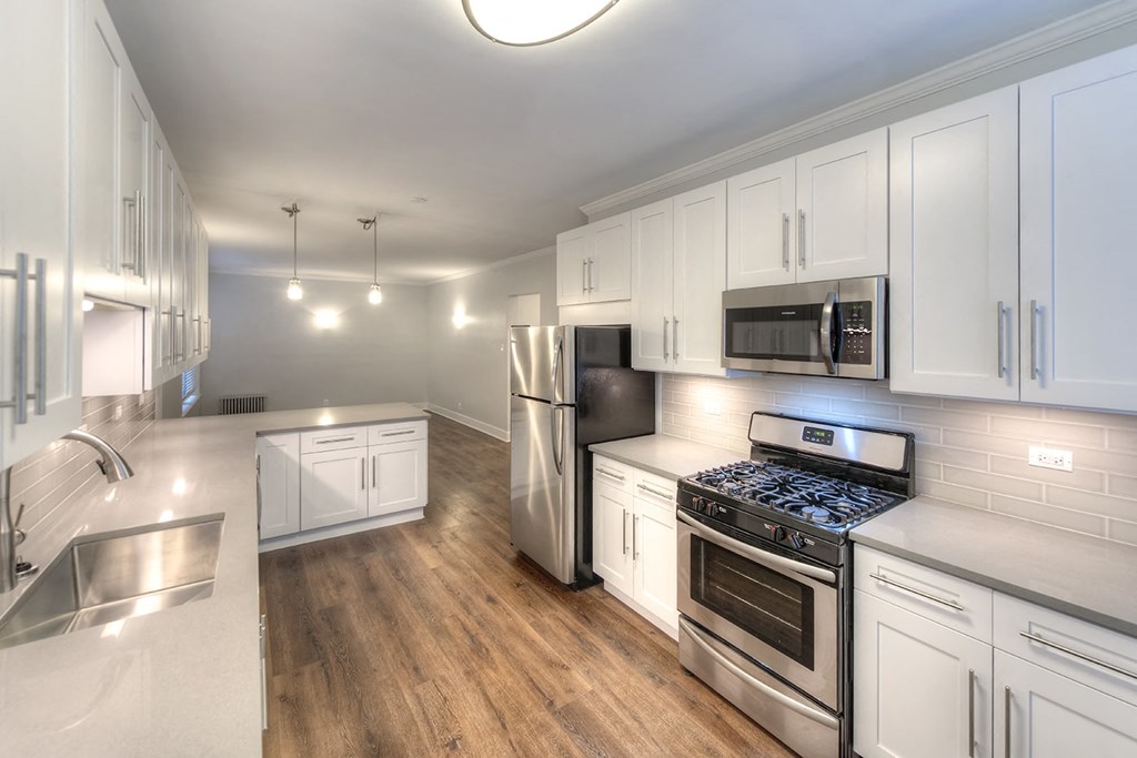a kitchen with white cabinets and stainless steel appliances