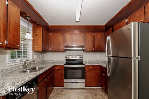 a kitchen with wood cabinets and granite counter tops and stainless steel appliances