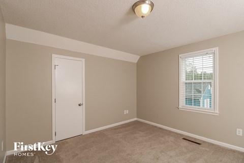 a bedroom with a white door and a window
