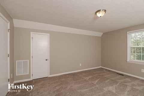 the living room of a home with a carpeted floor and a white door